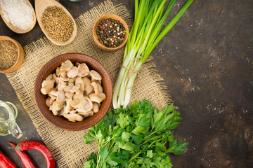 Pickled mushrooms in a bowl on a dark background. Mushrooms with herbs and spices. Fermented food. Pickled vegetables. Vegetarian food. View from above. Copy space. Food background.