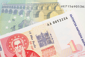 A Bulgarian one lev bank note with a red five euro German bank note close up in macro