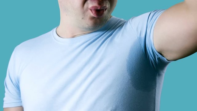 Young man having problem sweat under armpit. Young man sniffing his armpit, something stinks very bad. Bad smells concept.