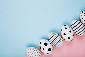 Many easter eggs on trendy pink pastel background. Eggs are hand-drawn. Flat lay style.