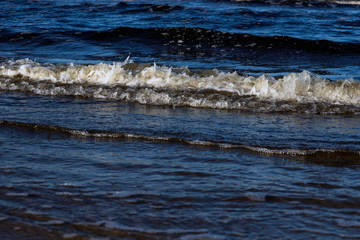 Waves with foam on the shore of the cold Baltic Sea