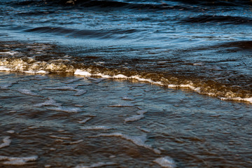 Waves with foam on the shore of the cold Baltic Sea