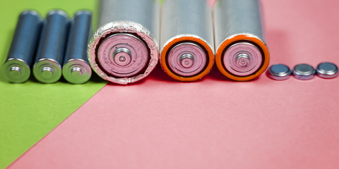 Many different types used or new battery, rechargeable accumulator, alkaline batteries on color...