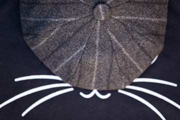 A Fashionable Gray Cap Covers an Image of Black Cat's Face, and Cute Mustache is Visible Only....