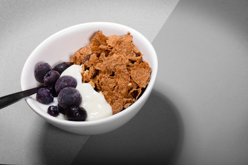 Breakfast cereal and blueberries in a bowl with yoghurt