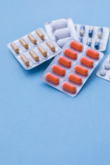 Tablets and pills on blue background, medicine drugs concept, toned