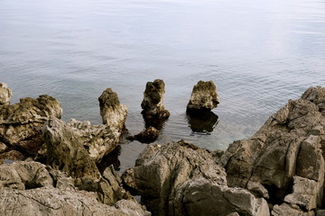 Karst and stony, rocky seashore with rocks rising from the sea