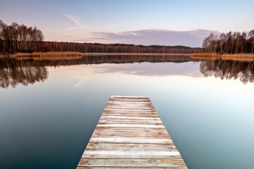 Obraz na płótnie Canvas Old wooden footbridge on the lake