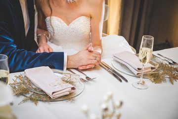 Wedding flowers on a table (bride and groom in a background)