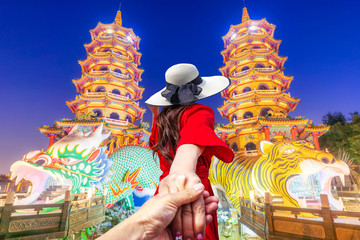  Asian women visit Dragon and the tiger pagoda at the lotus pond and the reflections at night.