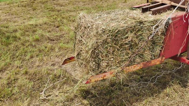 Footage of a hay bale maker working in the field...