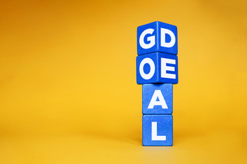 Wooden cube block flip over with word "goal" to "deal".