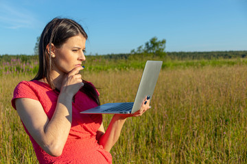 Caucasian girl with a laptop on the nature. Copyspace