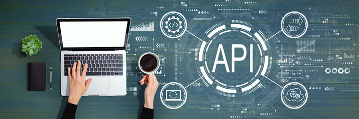 API - application programming interface concept API concept with person using a laptop computer
