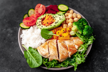 Bowl Buddha. rice, chicken breast, broccoli, pumpkin, avocado, chickpeas, carrots, cucumber, beets, a stone background