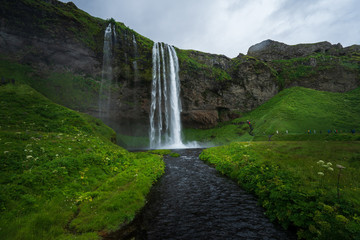 Seljalandsfoss in Iceland, on a cloudy day with river