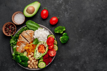 Bowl Buddha. rice, chicken breast, broccoli, pumpkin, avocado, chickpeas, carrots, cucumber, beets, a stone background  with copy space for your text