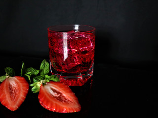 Fresh red cocktail with ice cubes and mint leaves. Red summer berries . Tasty juicy drink.