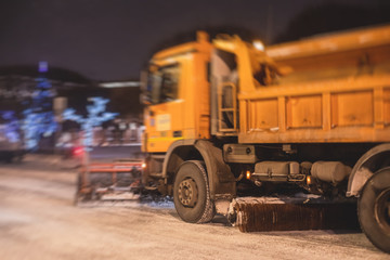 Obraz premium Process of snow removal on the city streets with municipal vehicle, bulldozer, snowblower plow truck, snowplow, snow removal equipment in winter night