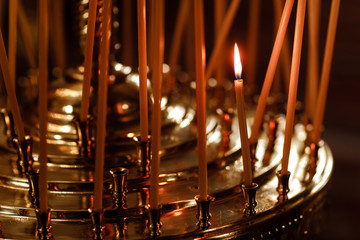 Many candles burning at night in church. Group of burning candles in dark. Close-up. copy space.
