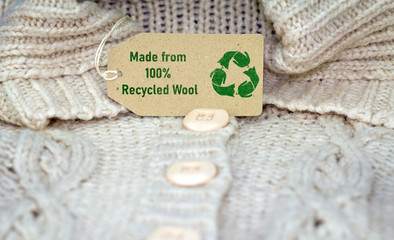 recycle wool text and recycle reuse symbol on wool jumper tag, sustainable zero waste living...