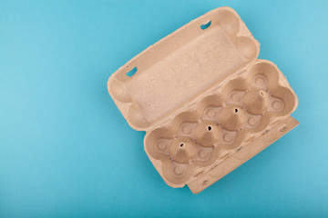 Egg Chicken eggs. Top view of an open empty gray box . Isolated on a blue background. The concept of a healthy lifestyle, getting pure protein. Proper Breakfast. Run out of eggs Shortage of chicken