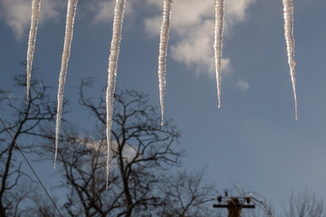 Icicles hang on the roof of the house