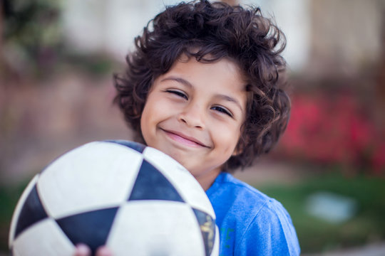 Smiling kid boy holding ball outdoor. Children, sport and activity concept