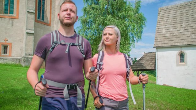 A walking wanderer couple with hiking gear and backpack exploring surroundings of Lese, Slovenia