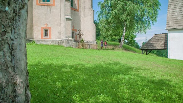 Panning shot of a walking wanderer couple with hiking gear and backpack exploring surroundings of Lese, Slovenia