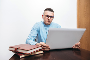 young man with glasses  working on his laptop