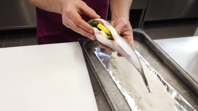 Chef putting dorade fish  onto plate