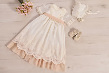 christening baby dress. Close-up of a cute newborn baby dress. Stylish embroidered white dress. Concept childhood education and fashion