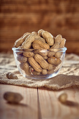 peanuts in a glass plate on a wooden table