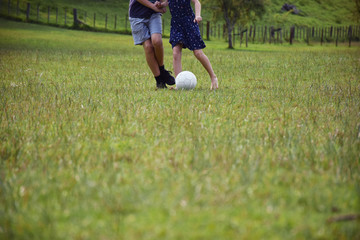 Kids play soccer football on a large grass lawn