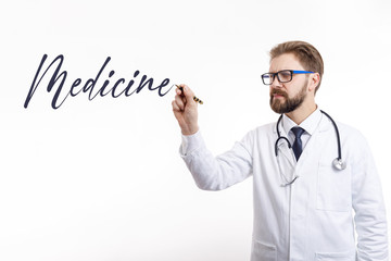 Handsome bearded medical employee in glasses writing the medicine word in air isolated white background