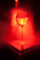 Goblet of white wine on wooden table on wooden wall background