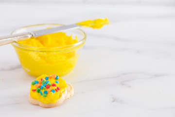 Cookies Decorated with Bright Yellow Colored Frosting with Fun Sprinkles