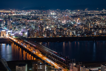 Fototapeta na wymiar Japan. Osaka. Evening panorama of the big city. Bridges over the Yodo river. A huge city in the dark time. The lights of the big city. Guide to Japan. Japanese landscapes. Urbanistics.