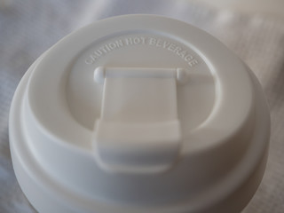 close-up of the lid of a non disposable white plastic cup