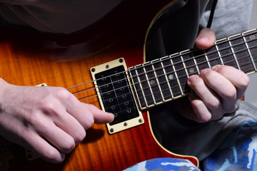 Fototapeta na wymiar Close up of hands playing a guitar