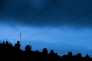 Silhouette of chimney pots against a blue sky