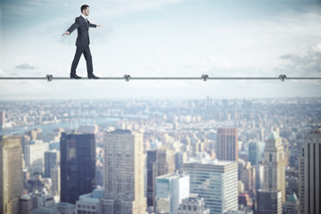 Businessman walking on rope