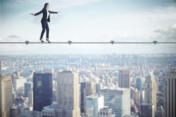 Businesswoman walking on rope