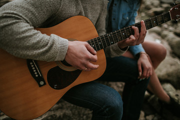 Close-up of men playing acoustic guitar to a girl