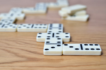Playing dominoes on a wooden table. Dominoes game concept.