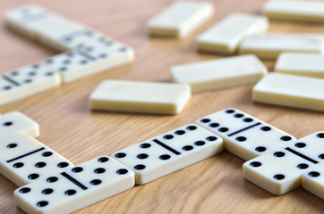 Playing dominoes on a wooden table. Dominoes game concept.