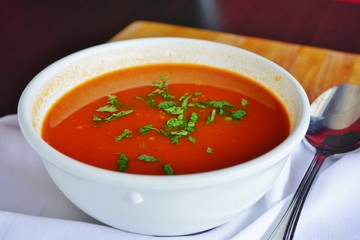 A bowl of tomato vegetable soup at an Indian restaurant