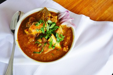 A dish of rogan josh red goat curry at an Indian restaurant