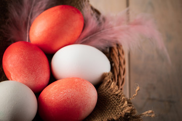 White and orange easter eggs on a light wooden background.